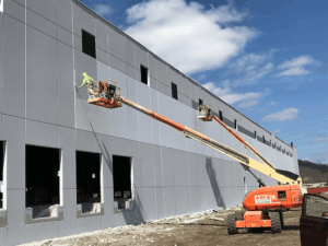 PAINTech employee painting the exterior of a commercial building. Commercial Painting Contractors: Why They're Essential to Your Bottom Line