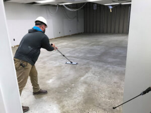 Man working on a commercial floor. Top 5 Ways Working with Commercial Flooring Contractors Reduces Labor Costs